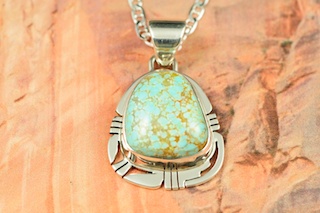 Genuine Number 8 Mine Turquoise Stone set in Sterling Silver Pendant. Free 18" Sterling Silver Chain with Purchase of Pendant. Created by Navajo Artist Phillip Sanchez. Signed by the artist. The Number 8 mine is located in Eureka County Nevada. Since 1976 there has been no Number 8 Turquoise mined. There is however, an existing stock pile that Mr. Dowell Ward, the last owner of the Number 8 mine, had stocked away for later sorting. The Turquoise is a collector's item--because once the reserve is gone there will be no more material released onto the market. The Gold Mining Company owns the claim to the Number 8 mine and it has been swallowed up by the gold mining operations. This is some of the last Number 8 Turquoise to be had and will be a great addition to your collection. 